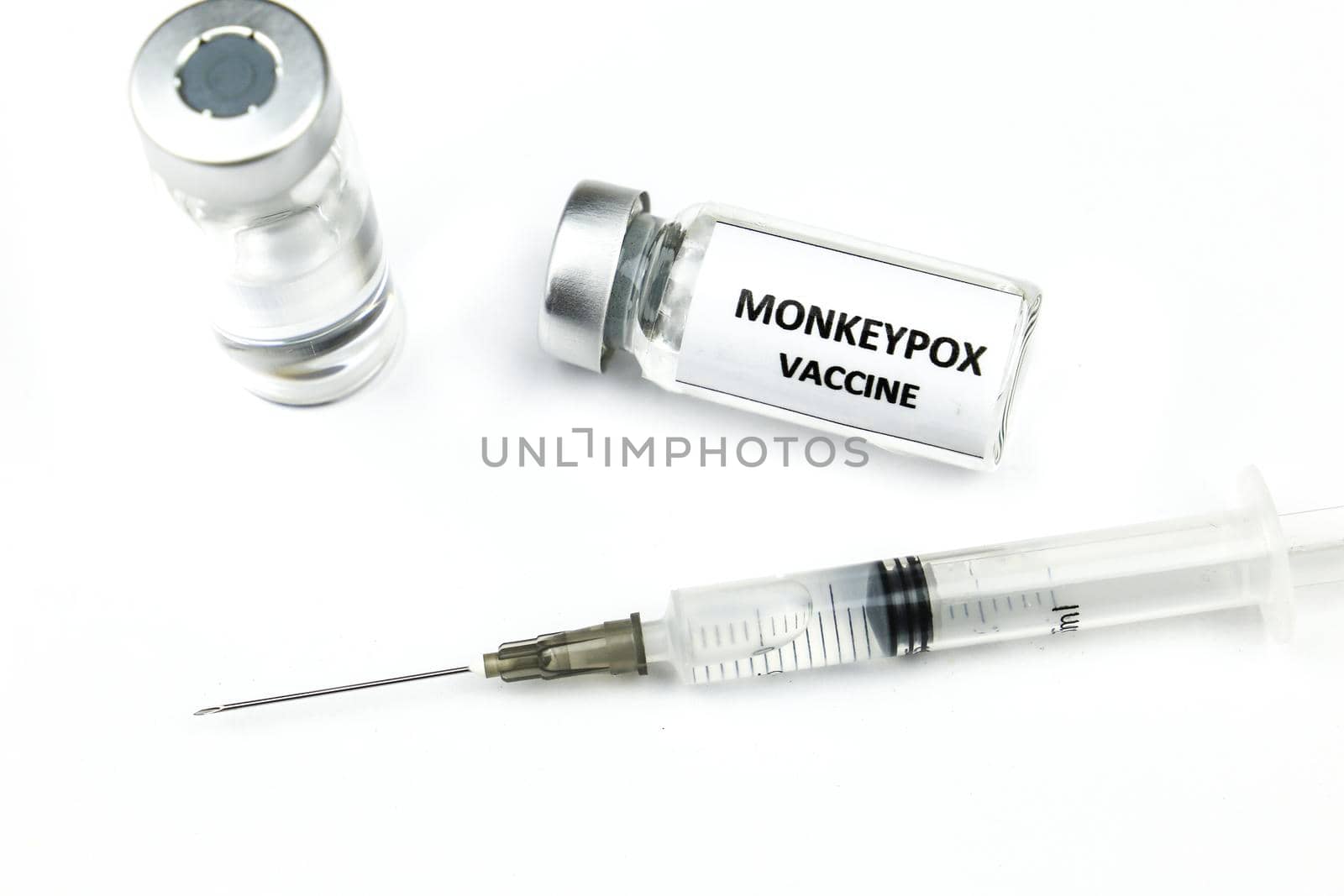 Close up picture of syringe and vials filled with Monkeypox vaccine on white background.