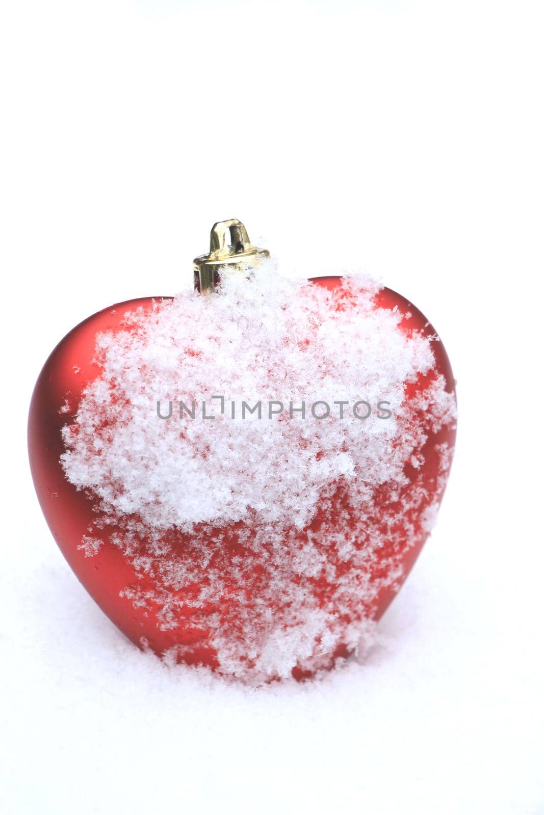 Red heart shaped ornament in fresh fallen snow