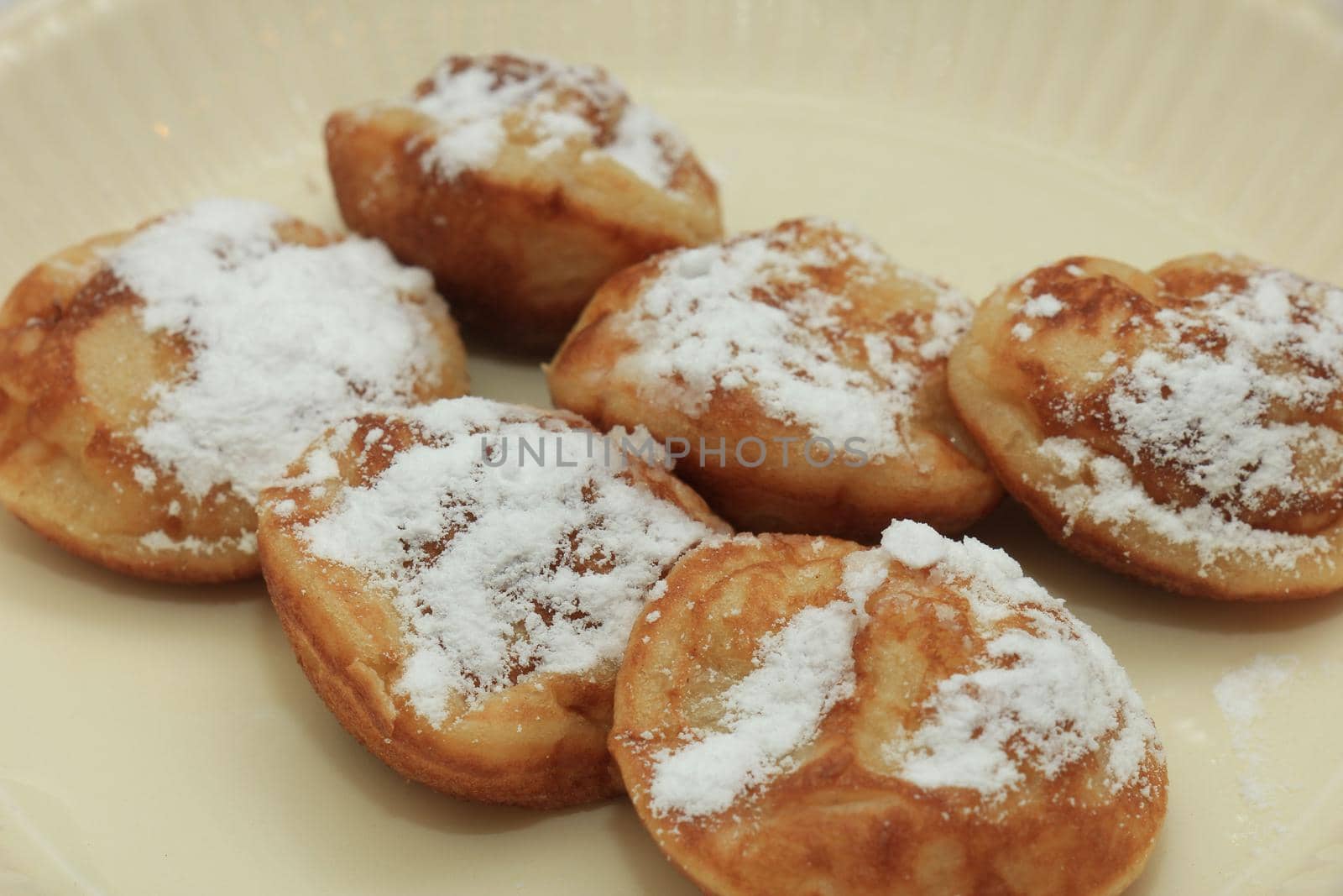 Poffertjes, Dutch small, fluffy pancakes, served with powdered sugar and butter.