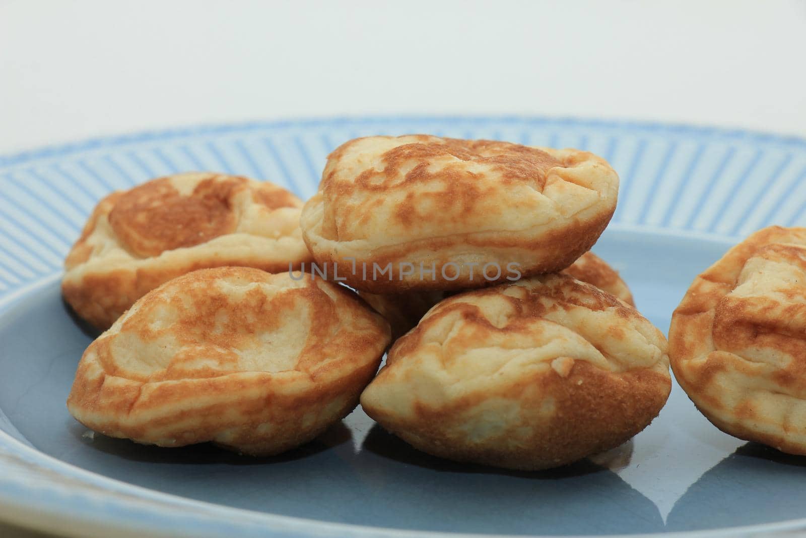 Poffertjes, Dutch small, fluffy pancakes, served with powdered sugar and butter.