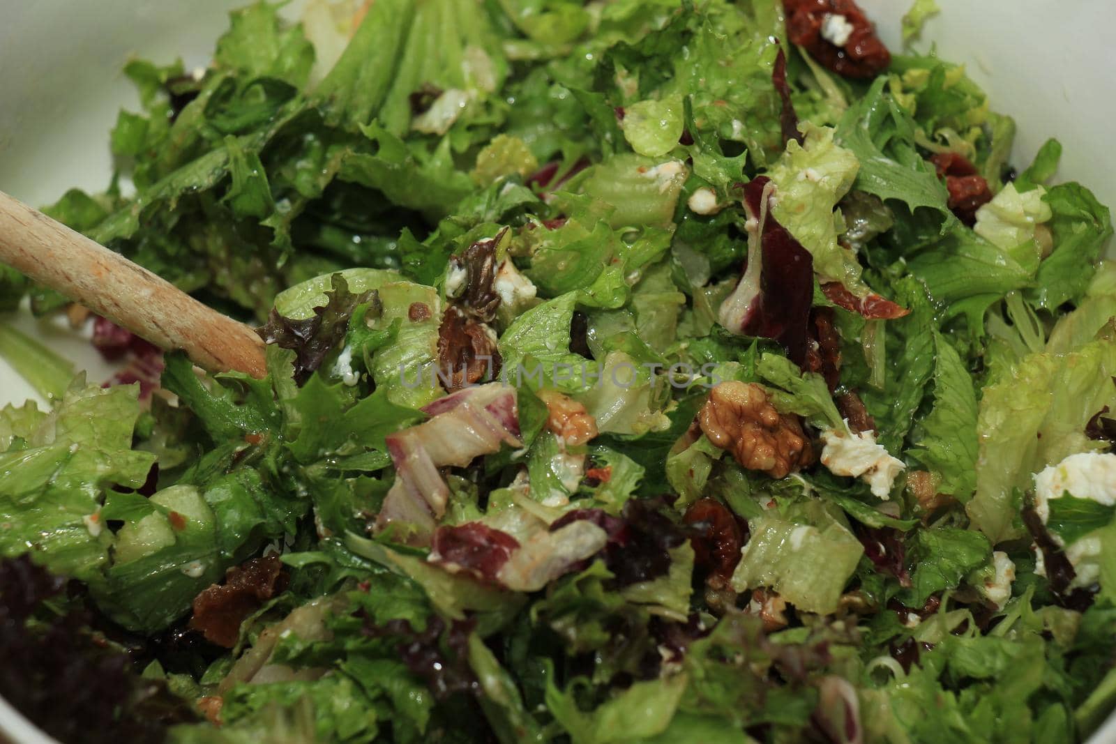 Green salad with walnuts, goat cheese and oil by studioportosabbia