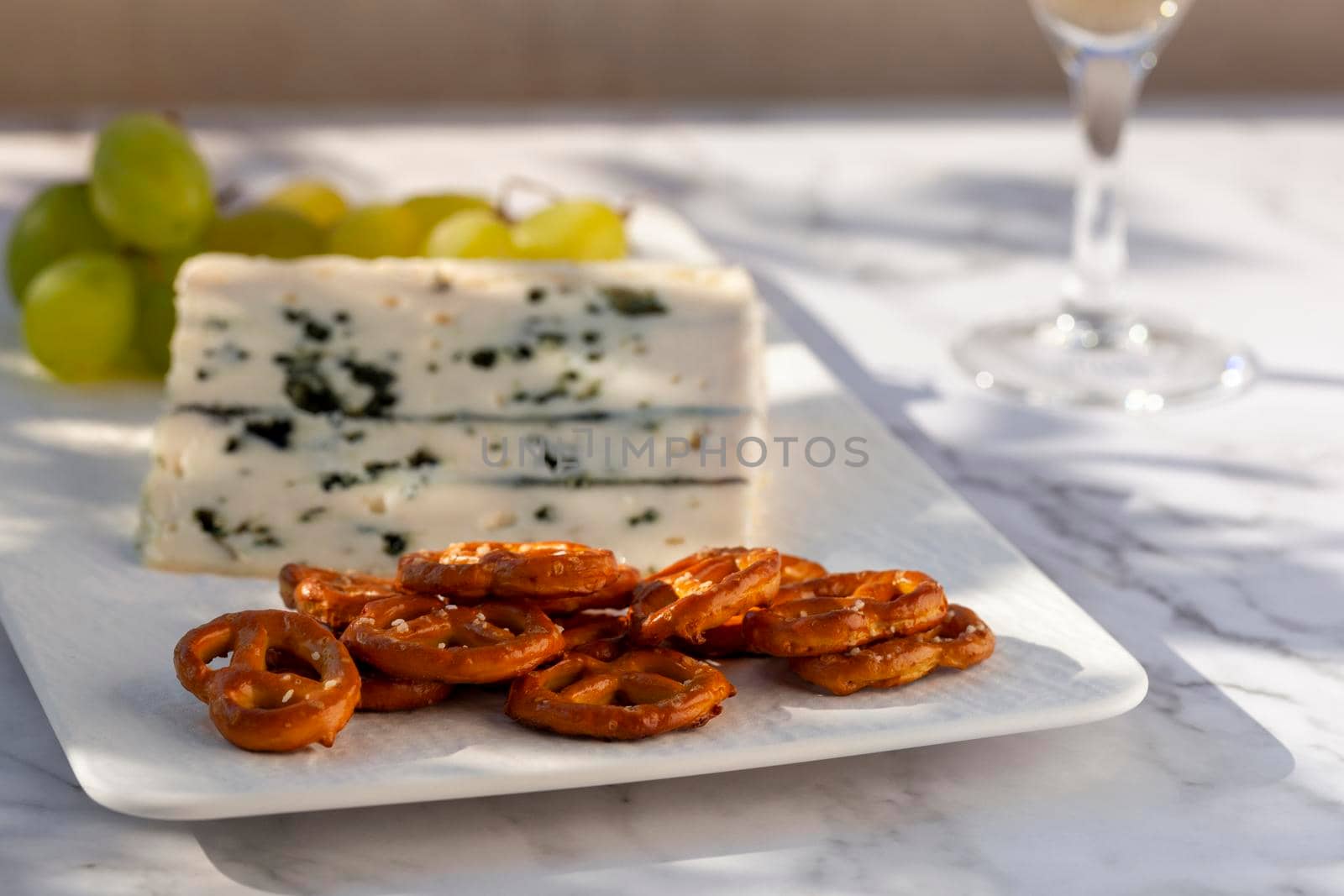 gorgonzola cheese served outdoors with green grapes, snacks and wine, hard light