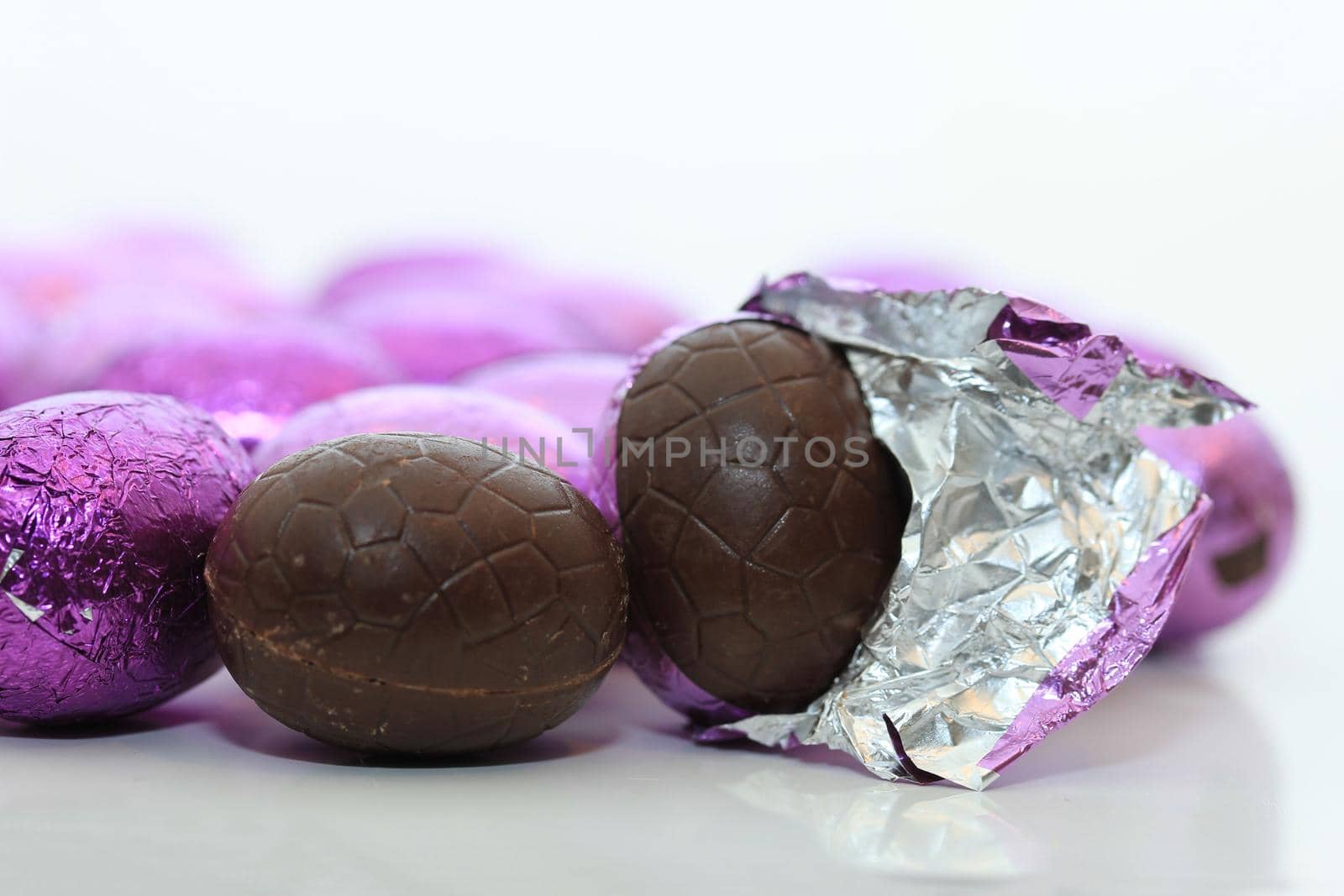 colorful wrapped chocolate easter eggs in close-up, macro by studioportosabbia