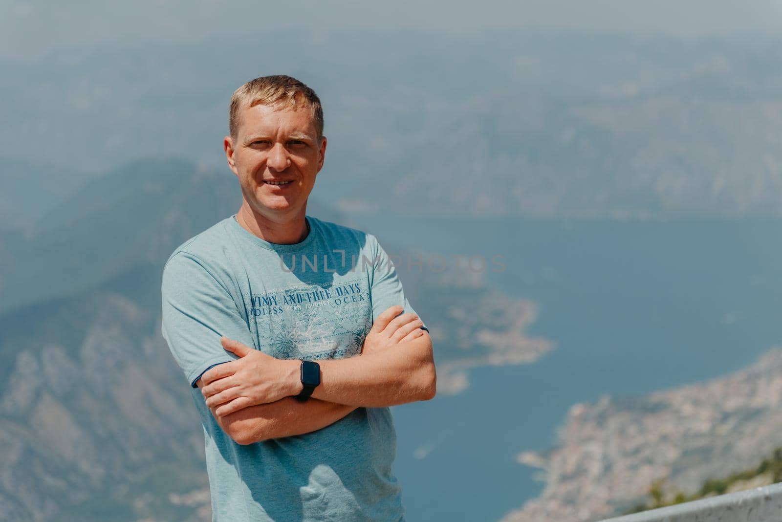 Man tourist enjoys the view of Kotor. Montenegro. Bay of Kotor, Gulf of Kotor, Boka Kotorska and walled old city. Travel to Montenegro concept. Fortifications of Kotor is on UNESCO World Heritage by Andrii_Ko