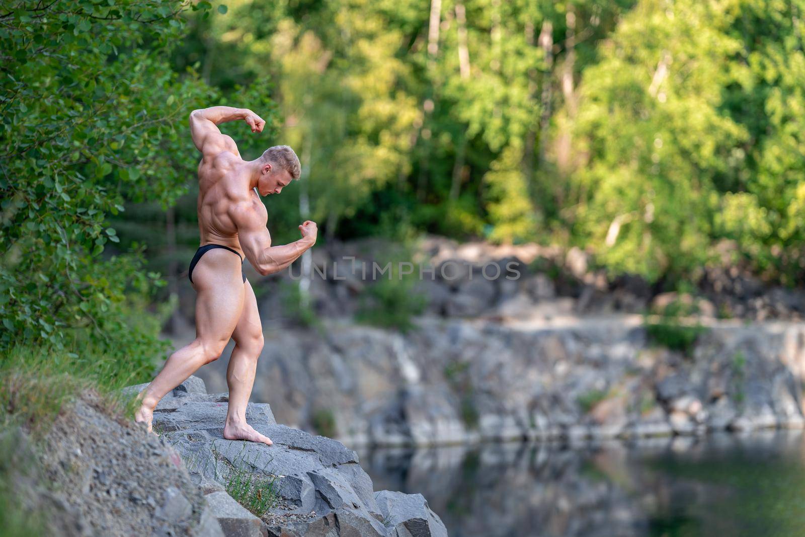 male bodybuilder by the water in nature by Edophoto