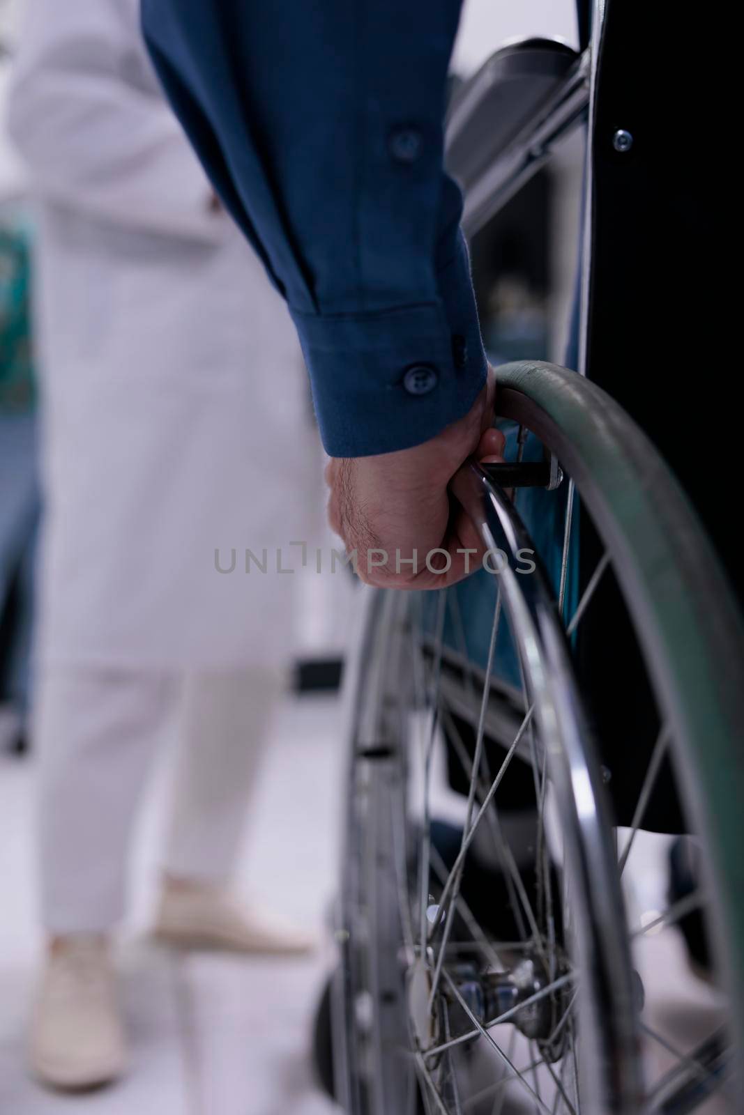 Selective focus on senior man living with disability in front of medical doctor for appointment by DCStudio