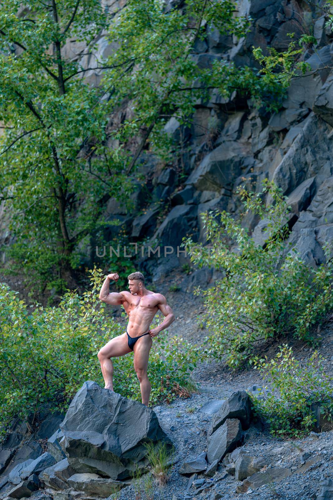 male bodybuilder on the rok in nature, fitness and healthy by Edophoto