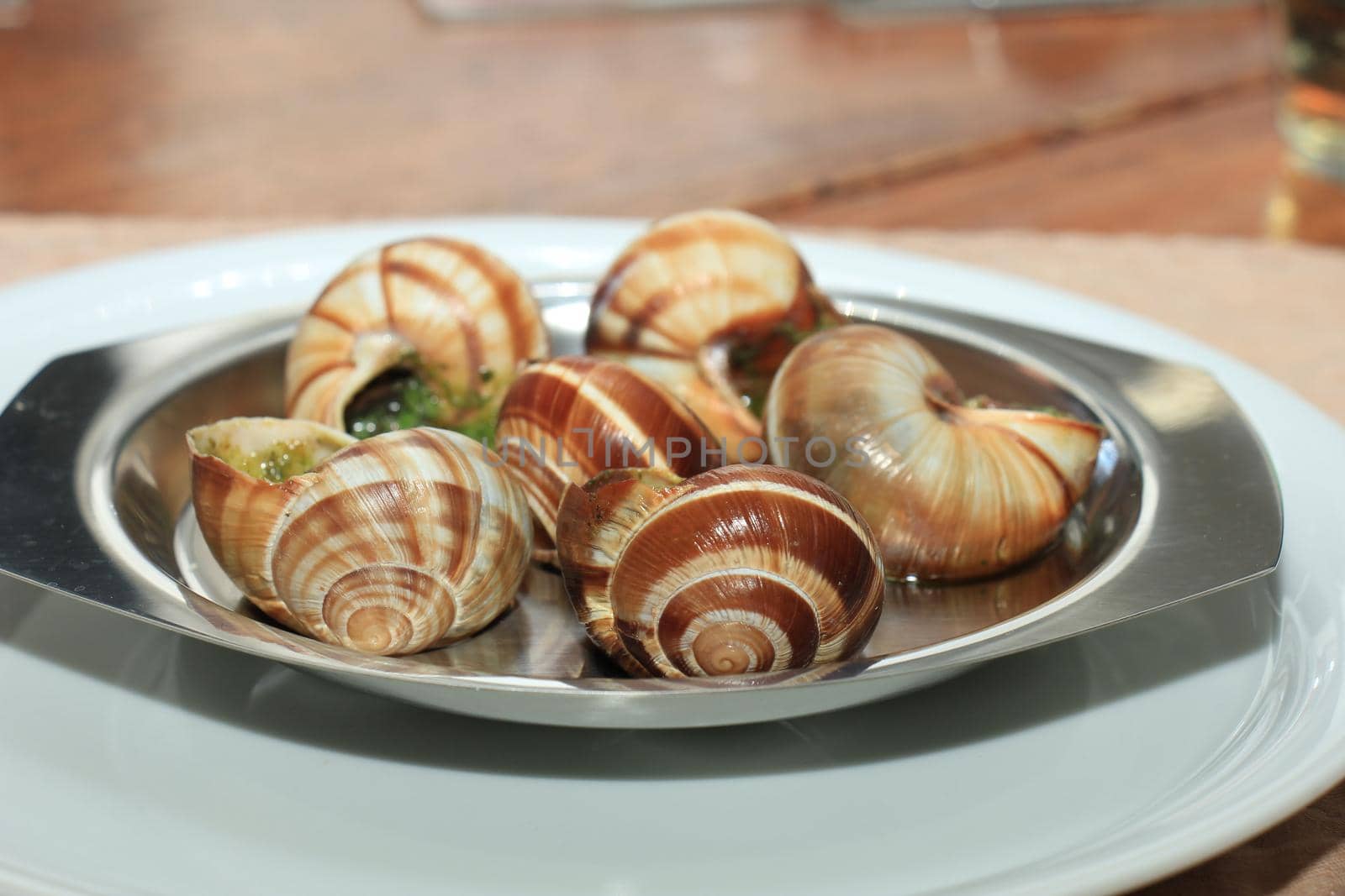 Escargots de Bourgogne on a metal plate, just out of the oven by studioportosabbia