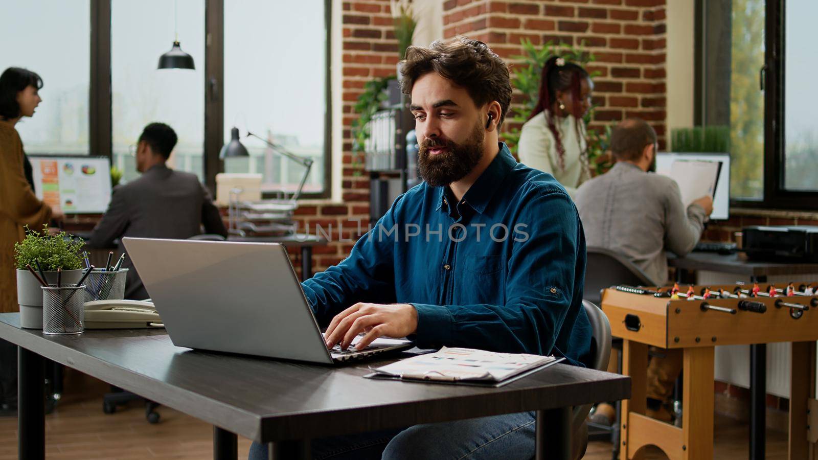 Office worker talking on remote video call conference at desk, using online virtual communication with webcam to chat with colleagues. Using videoconference telecommunications call.