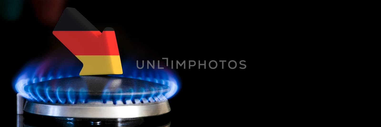 Decreased gas supplies in Germany. A gas stove with a burning flame and an arrow in the colors of the Germany flag pointing down. Concept of crisis in winter and lack of natural gas. Heating season