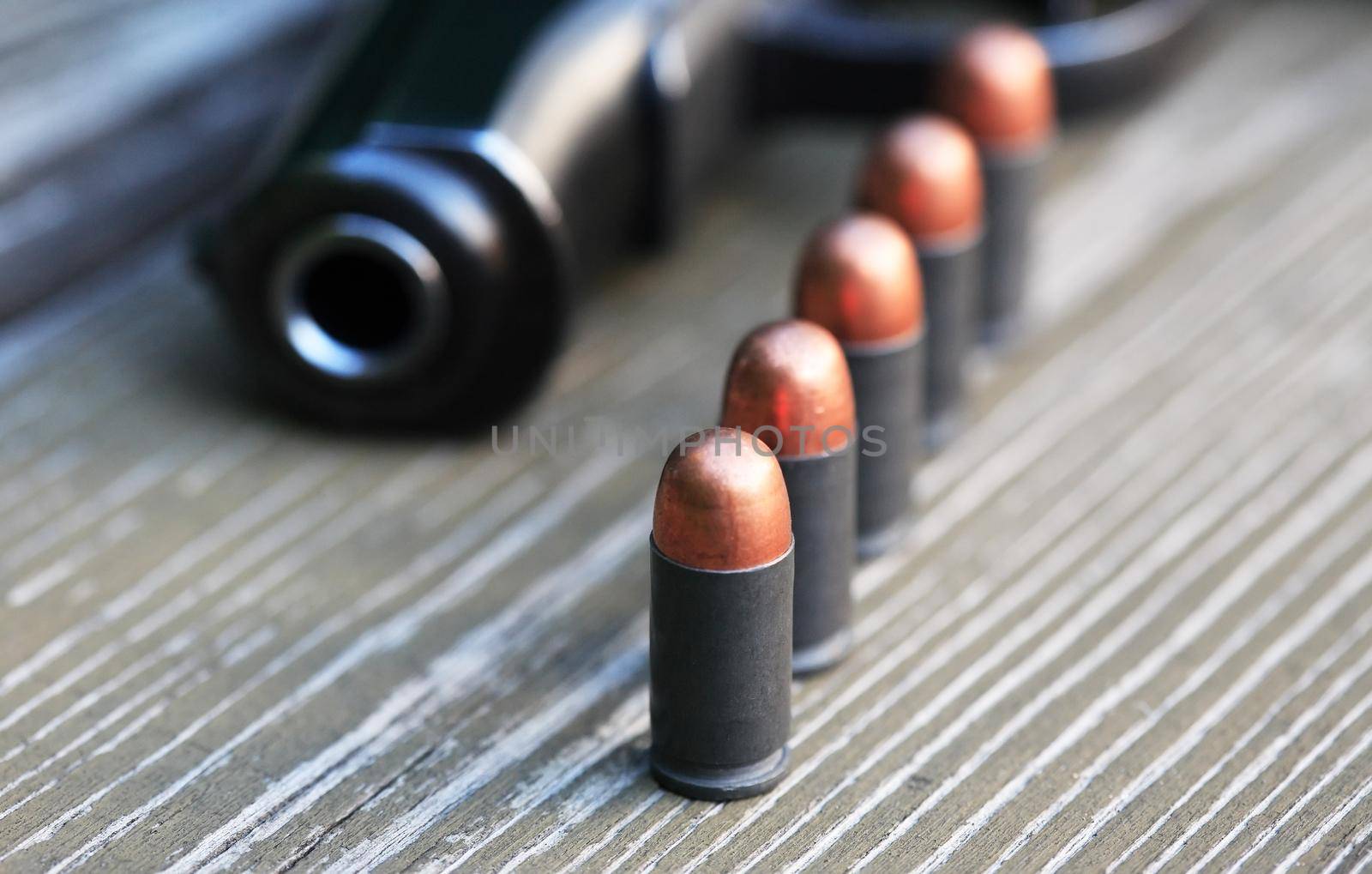 Handgun cartridges closeup on old wooden background near pistol