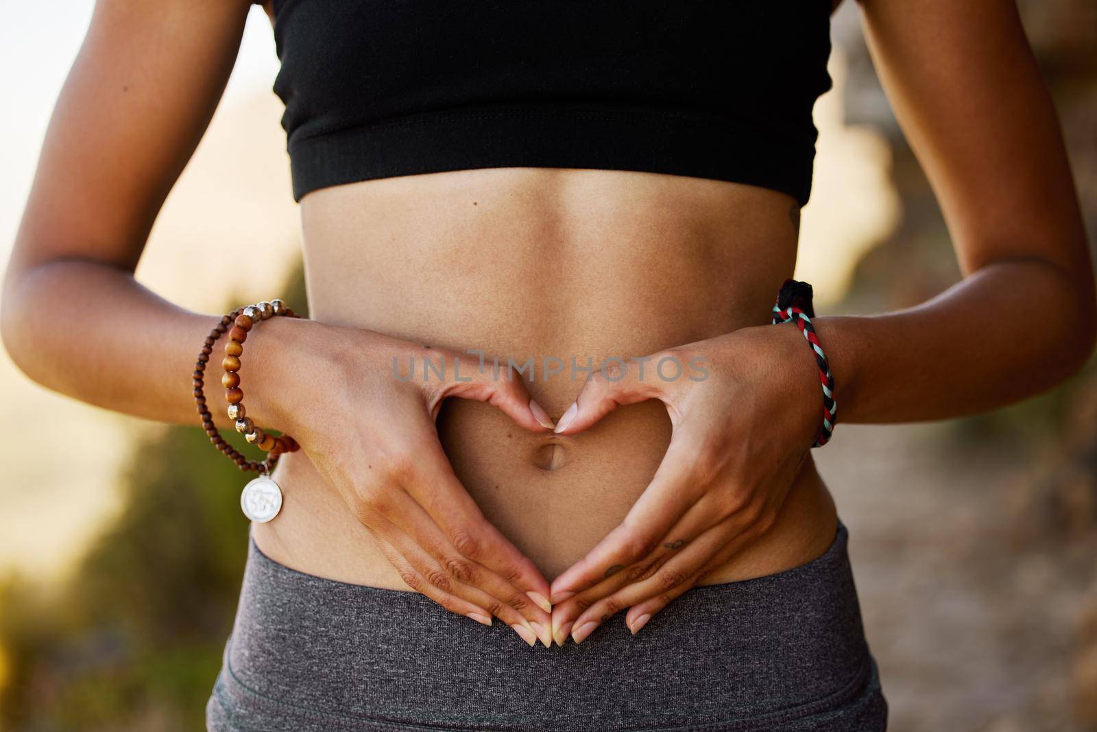 Theres nothing your body loves more than a good workout. a young woman forming a heart shape over her stomach
