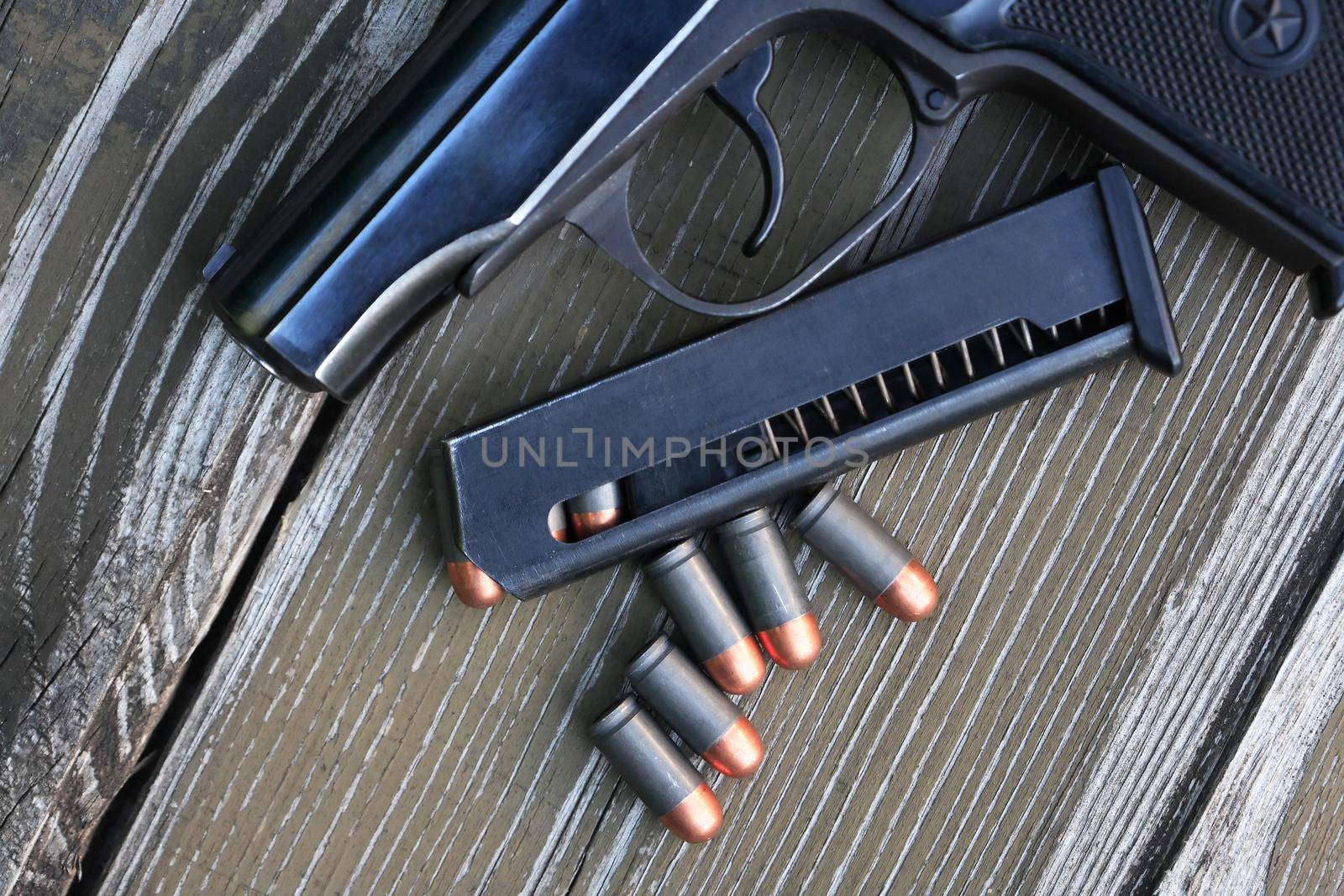 Handgun cartridges closeup on old wooden background near pistol