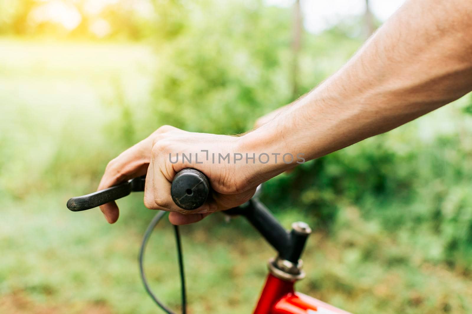 Side view of hands on bicycle handlebars, Close up of hands on bicycle handlebars. Concept of cyclist hands on the handlebars by isaiphoto