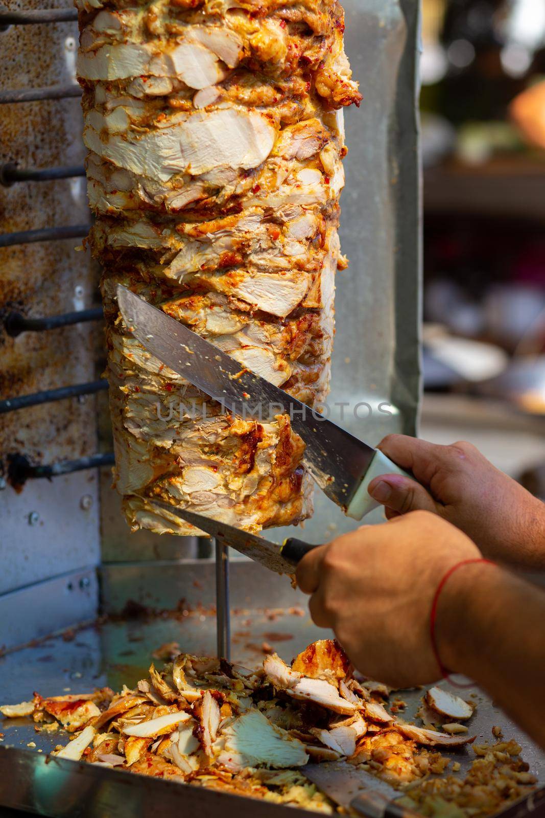 Chef cutting with doner knife Traditional Turkish Doner Kebab meat. Shawarma or gyros. Turkish, greek or middle eastern arab style chicken doner kebab food.