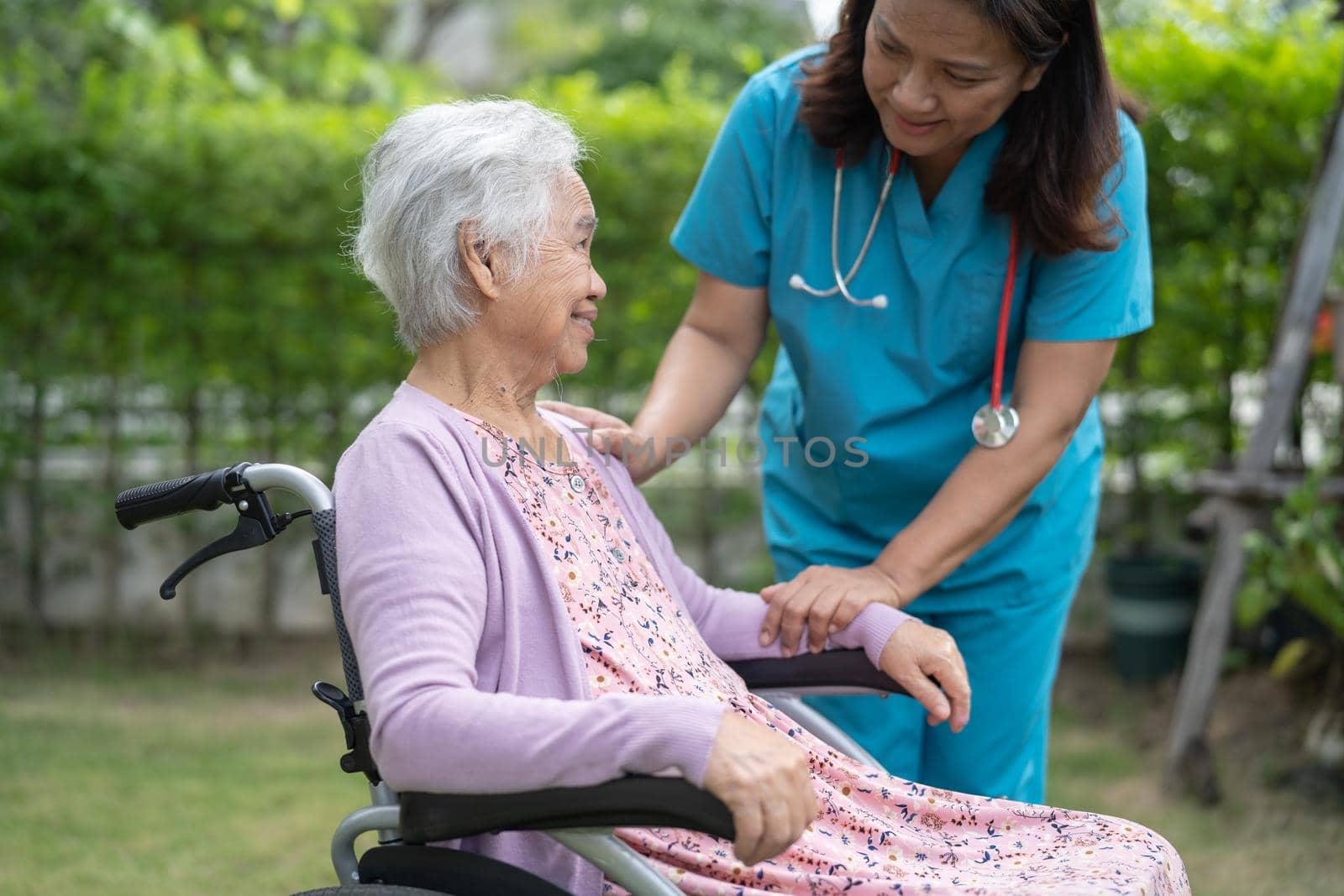 Doctor caregiver help and care Asian senior or elderly old lady woman patient sitting on wheelchair at nursing hospital ward, healthy strong medical concept by pamai
