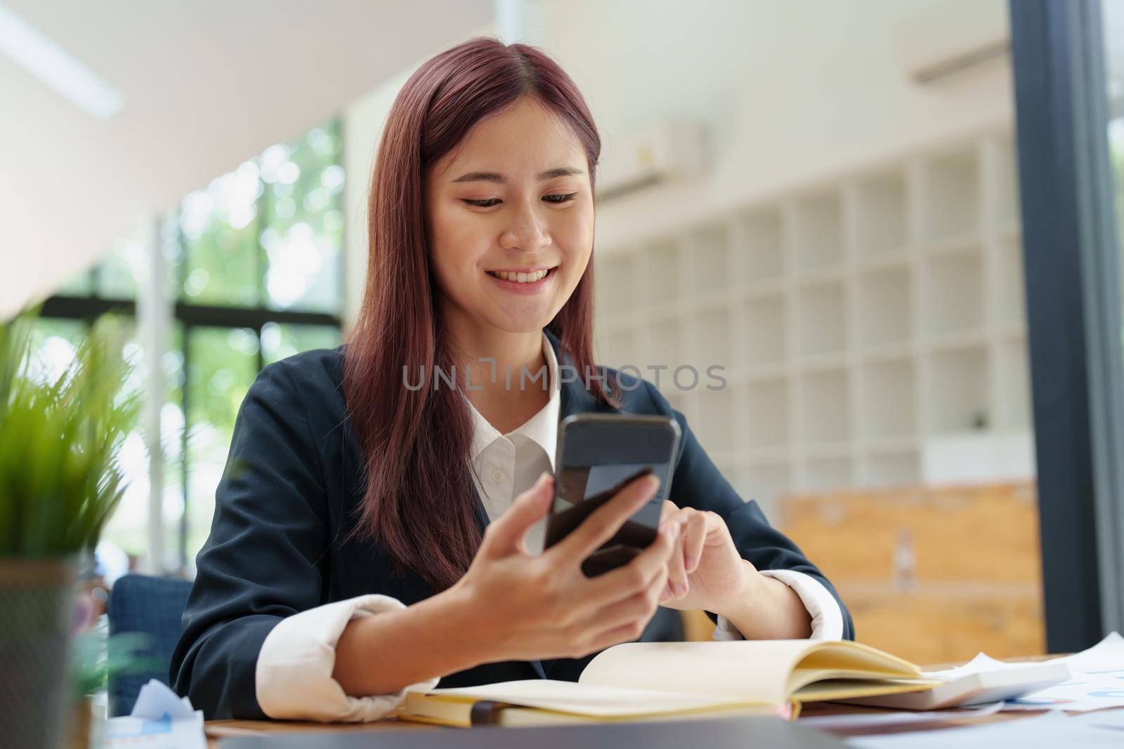 Asian businesswoman using the phone to contact a business partner.