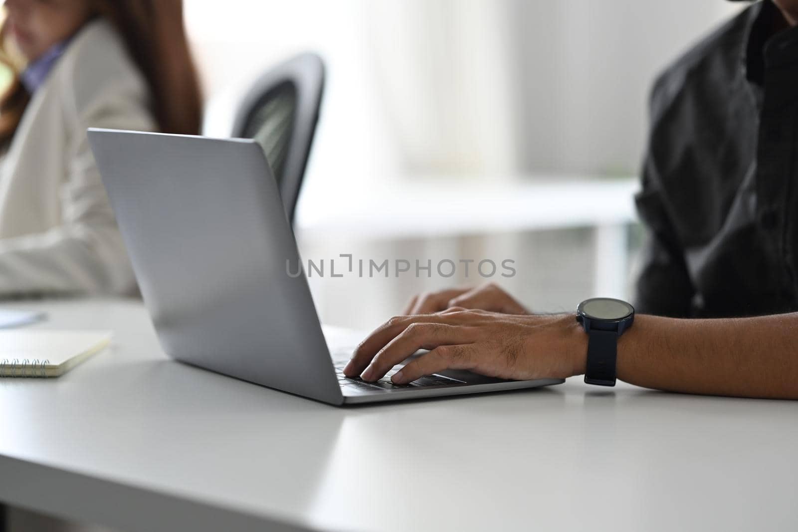 Cropped view of male employee typing business email, checking information on laptop computer.