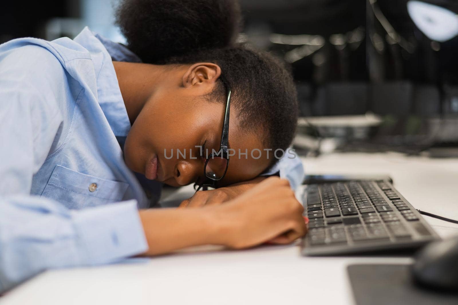 African young woman sleeping at work desk. by mrwed54