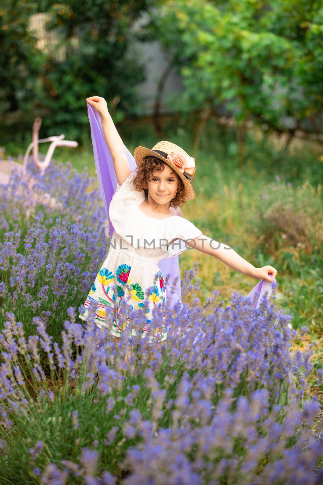 Romantic portrait o charming girl in straw hat in lavender bushes