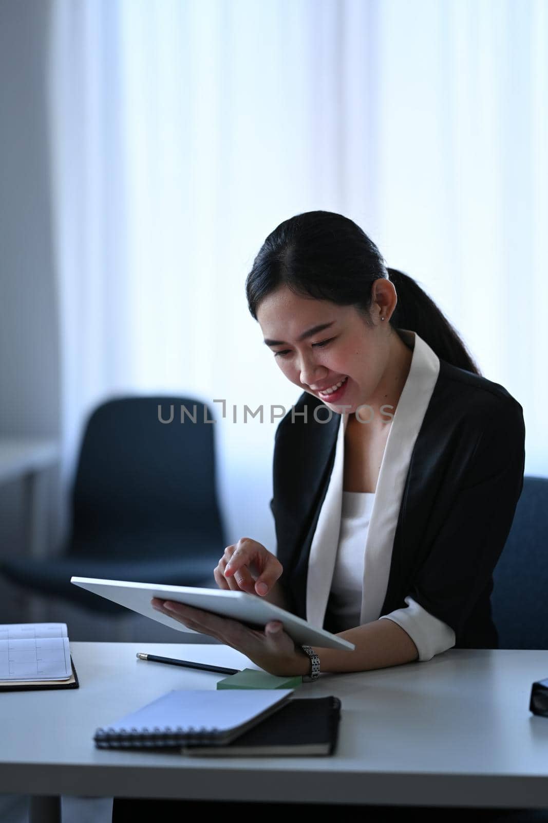Smiling businesswoman checking information on digital tablet.