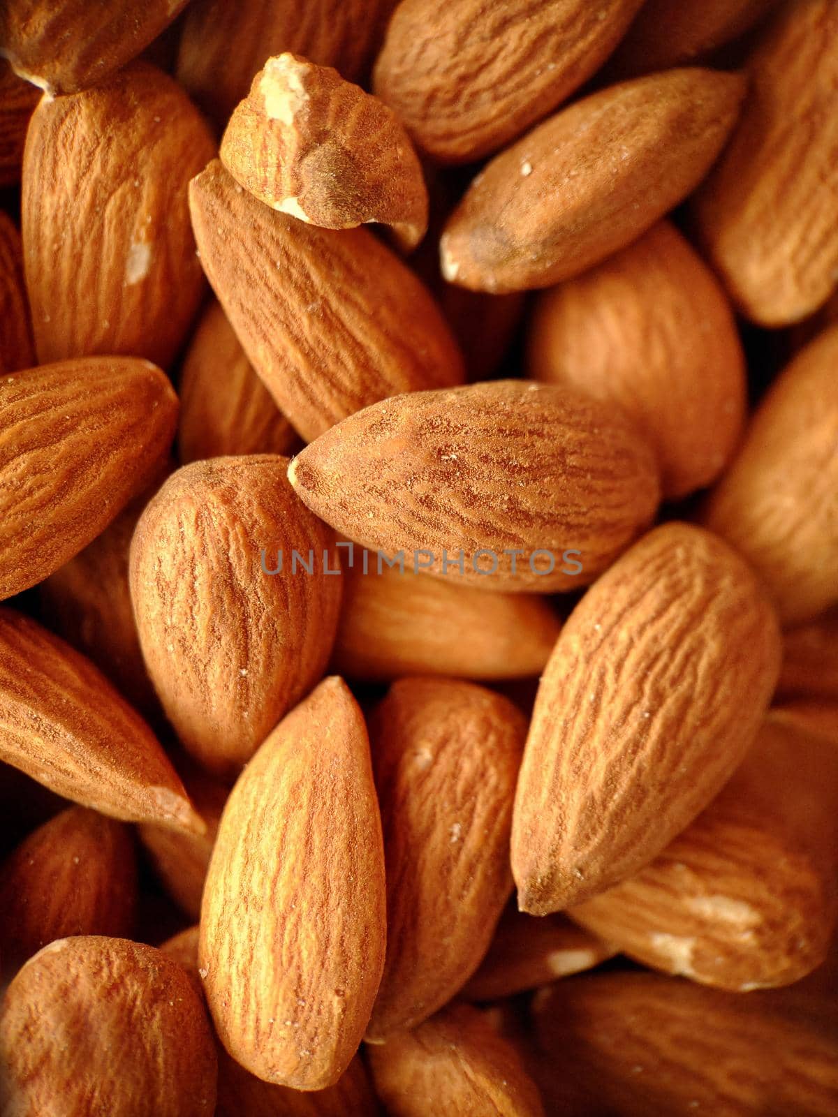 Macrophotography. A handful of large ripe peeled almonds of brown color.Texture or background