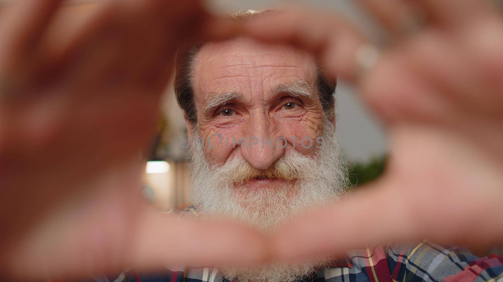 I love you. Senior grandfather makes symbol of love, showing heart sign to camera, express romantic feelings, express sincere positive feelings. Charity, gratitude, donation. Man close-up happy face