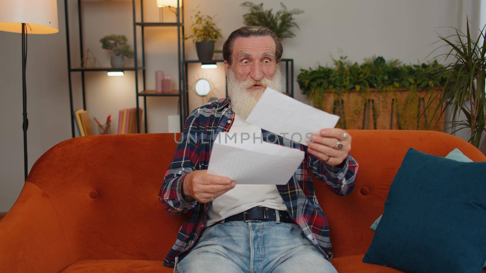 Senior man open envelope letter, reading it. Career growth advance promotion, bank loan approve, successful admission to university monetary award long-awaited invitation great news, lottery game win