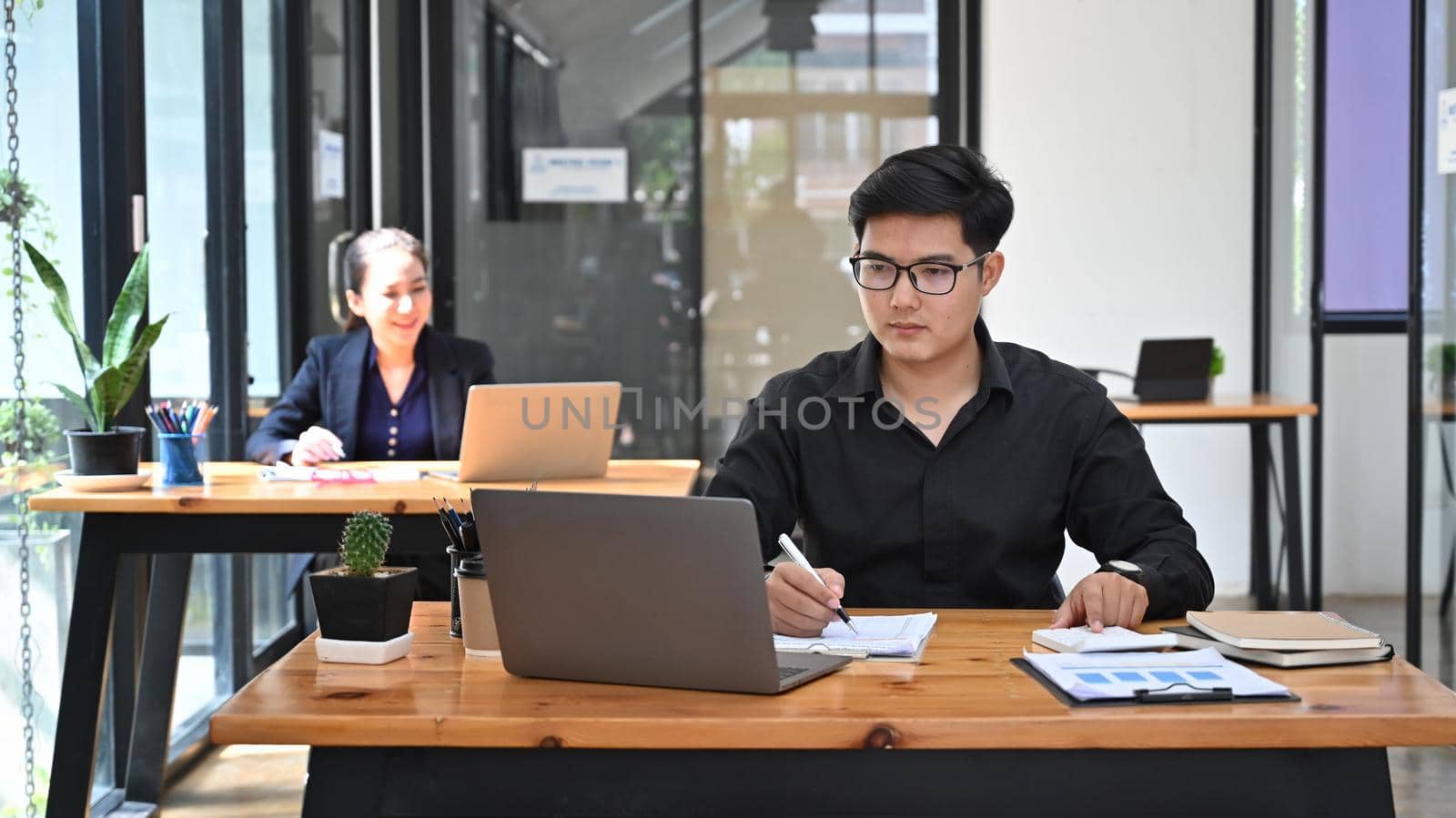 Handsome asian businessman working with laptop in modern office.