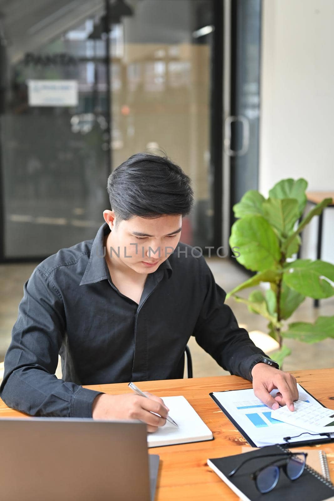 Young businessman working in comfortable workplace. by prathanchorruangsak