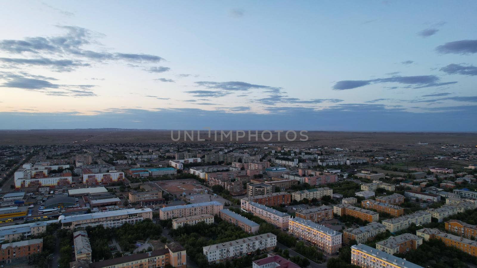 Dark clouds on horizon. Sunset over a small town by Passcal