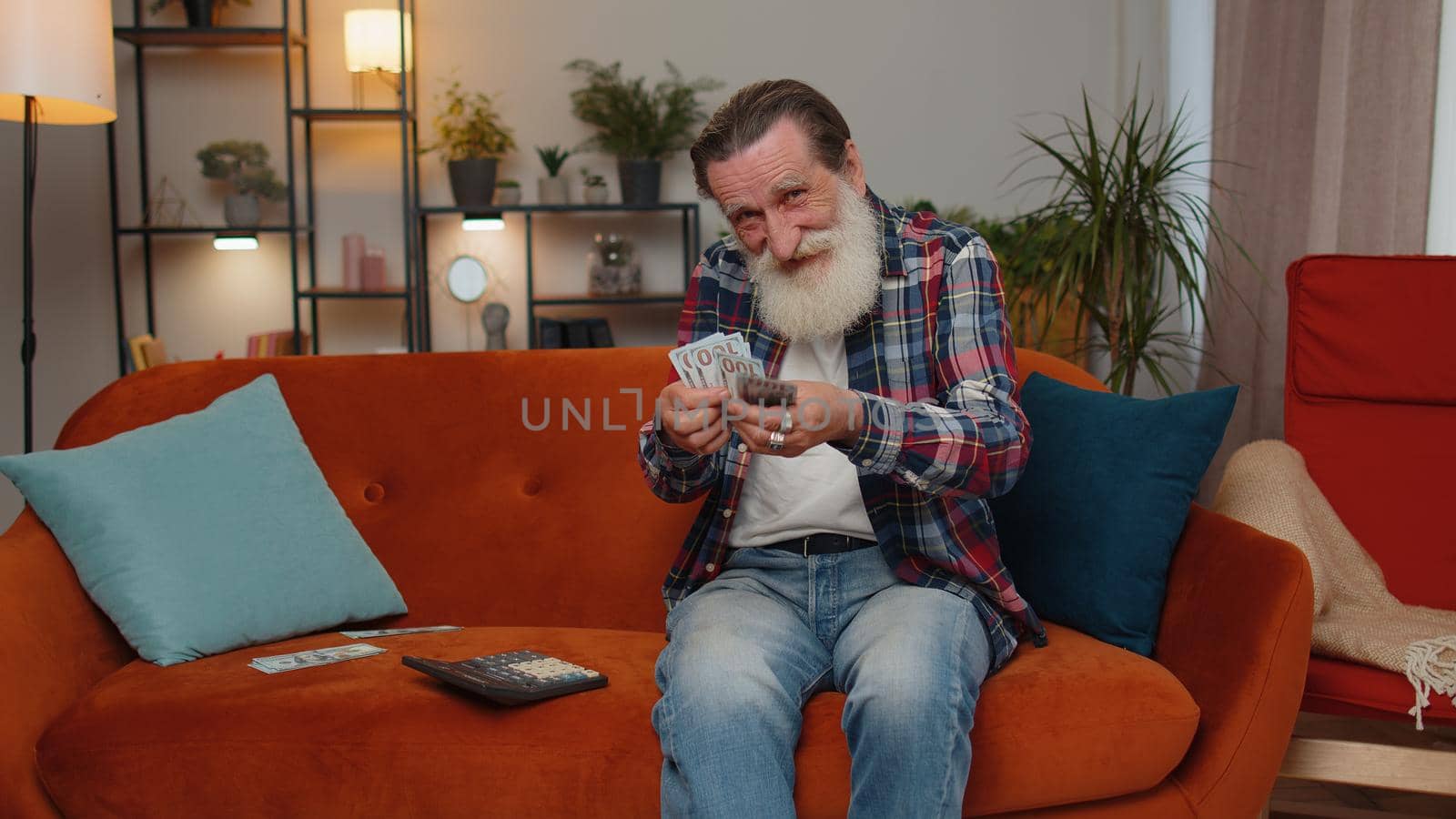 Planning budget. Rich happy senior grandfather counting money cash use calculator and calculate domestic bills at home. Man satisfied of income earnings, win, saves money for planned vacation, gifts