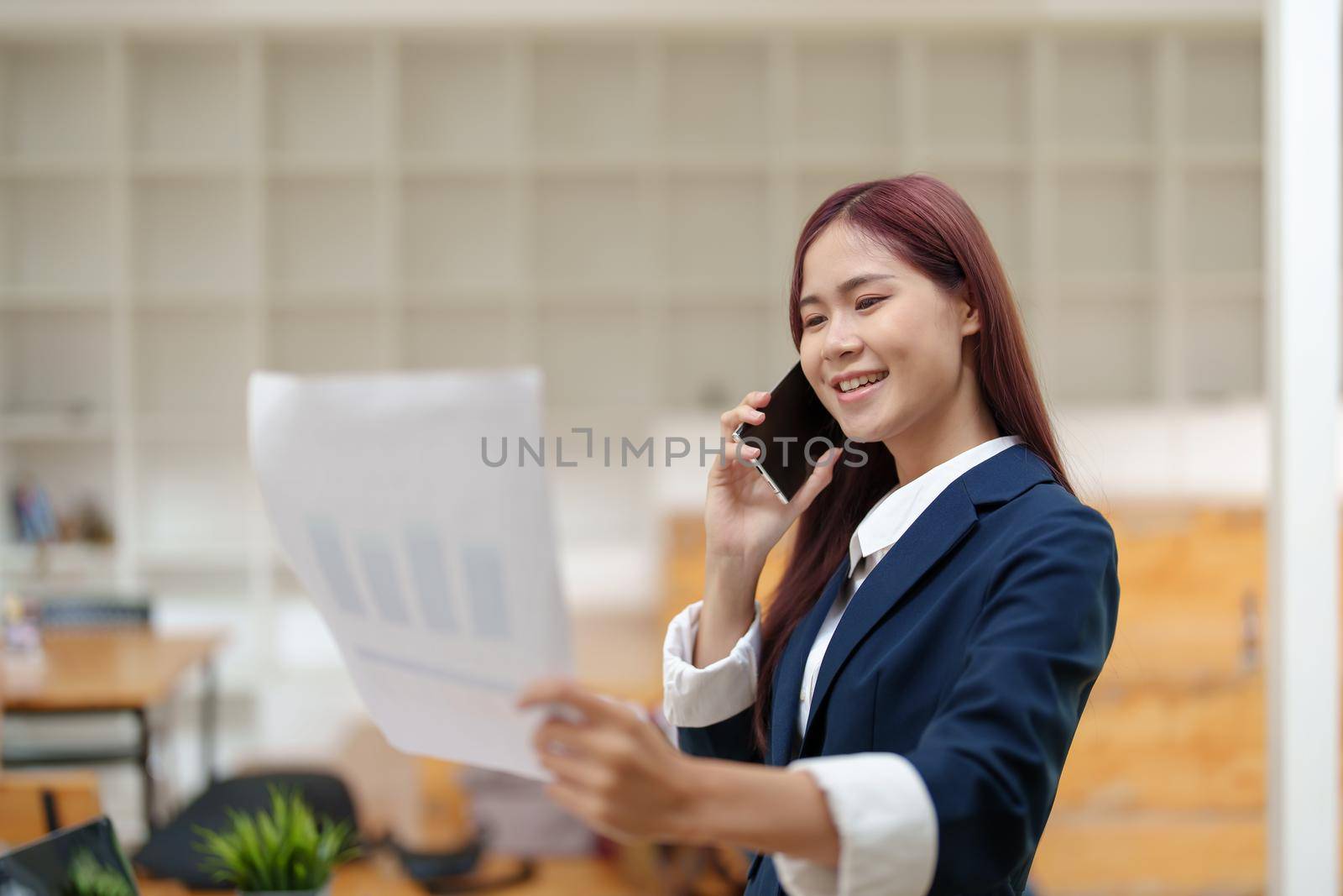 Asian businesswoman using the phone to contact a business partner.