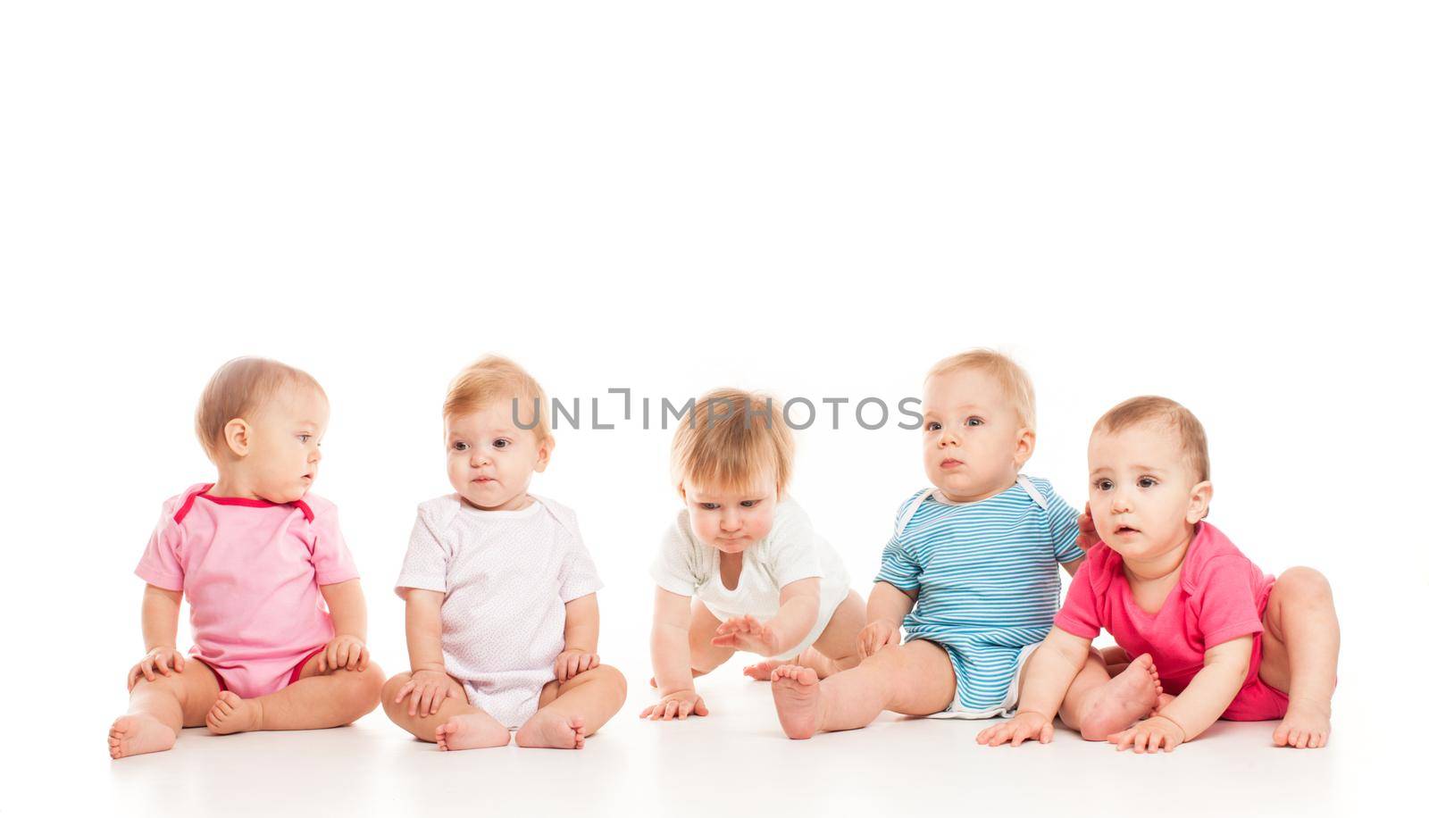 Group of witty babies sitting in different clothes, isolated on white background