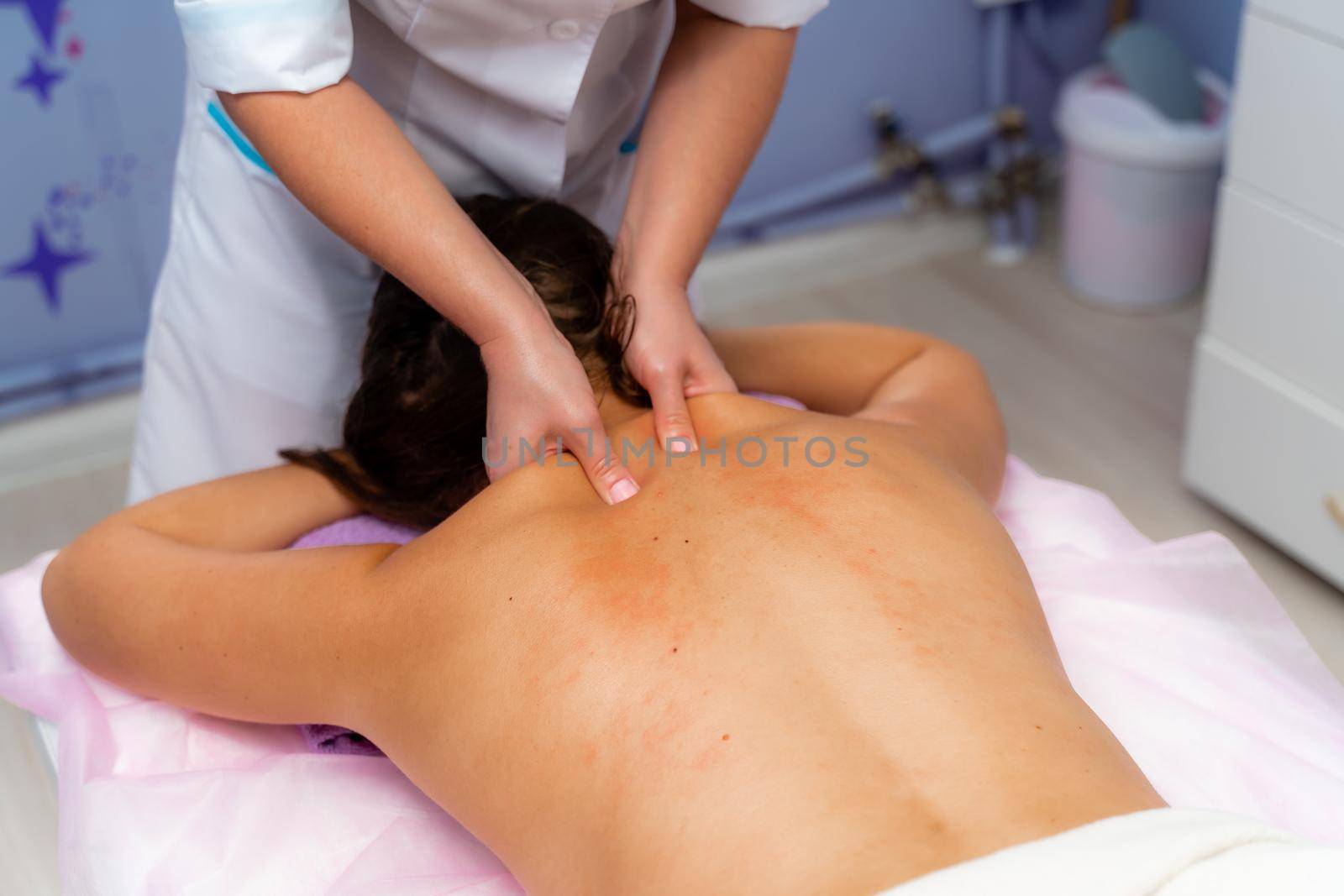 Facial massage. A woman is given a massage in a beauty salon. Close-up