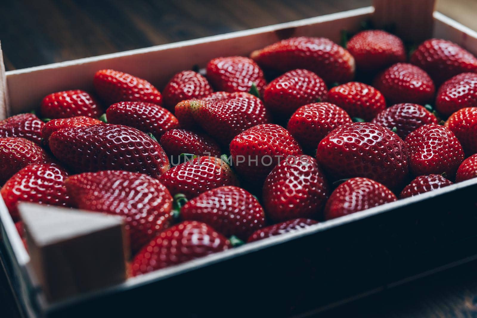 strawberries in a wooden box on a wooden table, healthy sweet food, vitamins and fruity concept. Food frame background