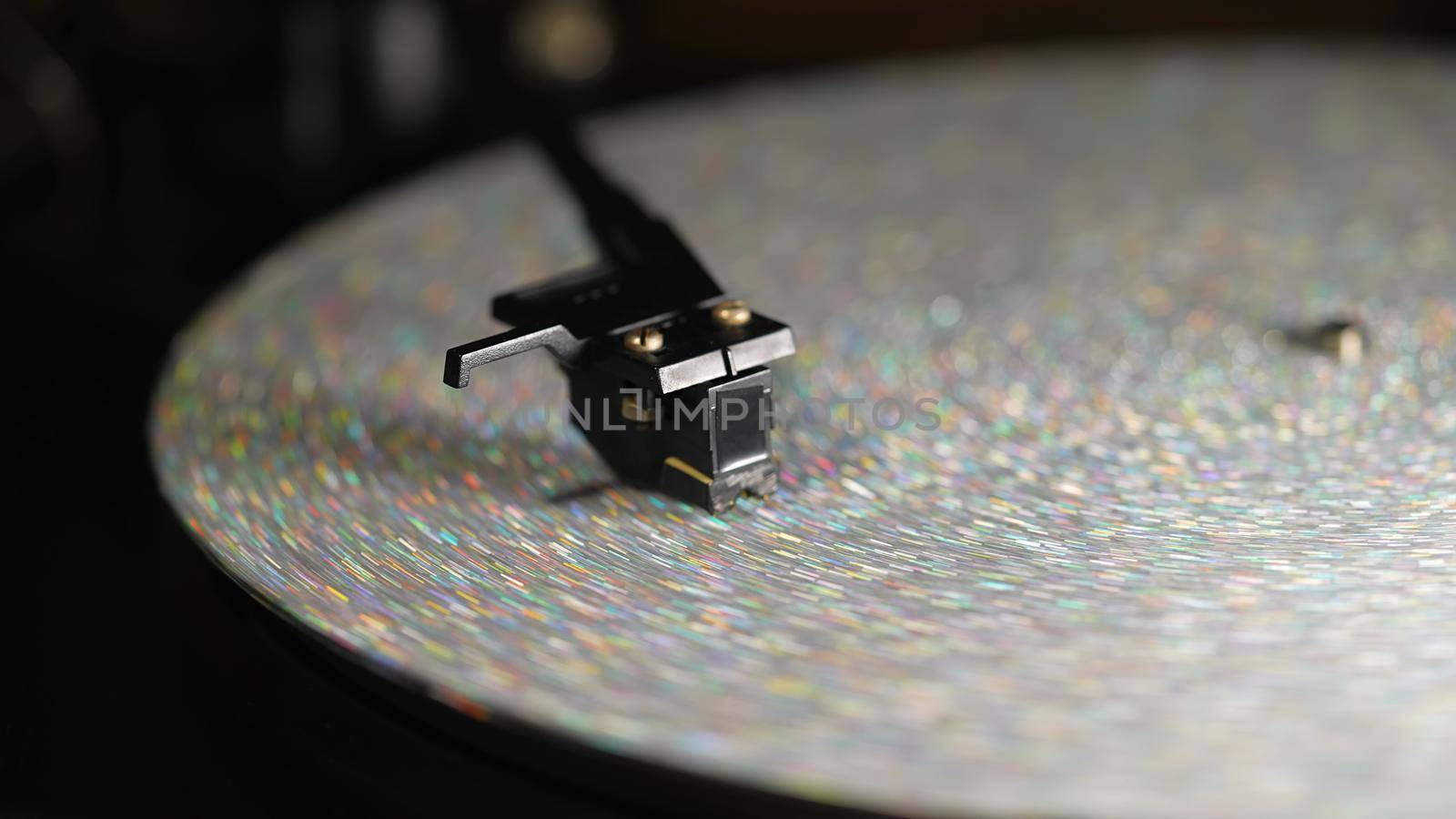 Retro-styled spinning silver record vinyl player. Close up glitter surface. Rotating vintage phonograph. Beautiful picture. Copy space,. High quality photo