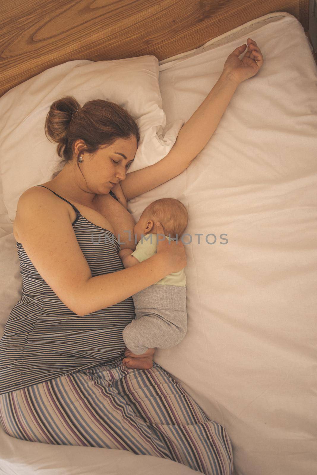 Mother and newborn baby sleep in the bed by oksix