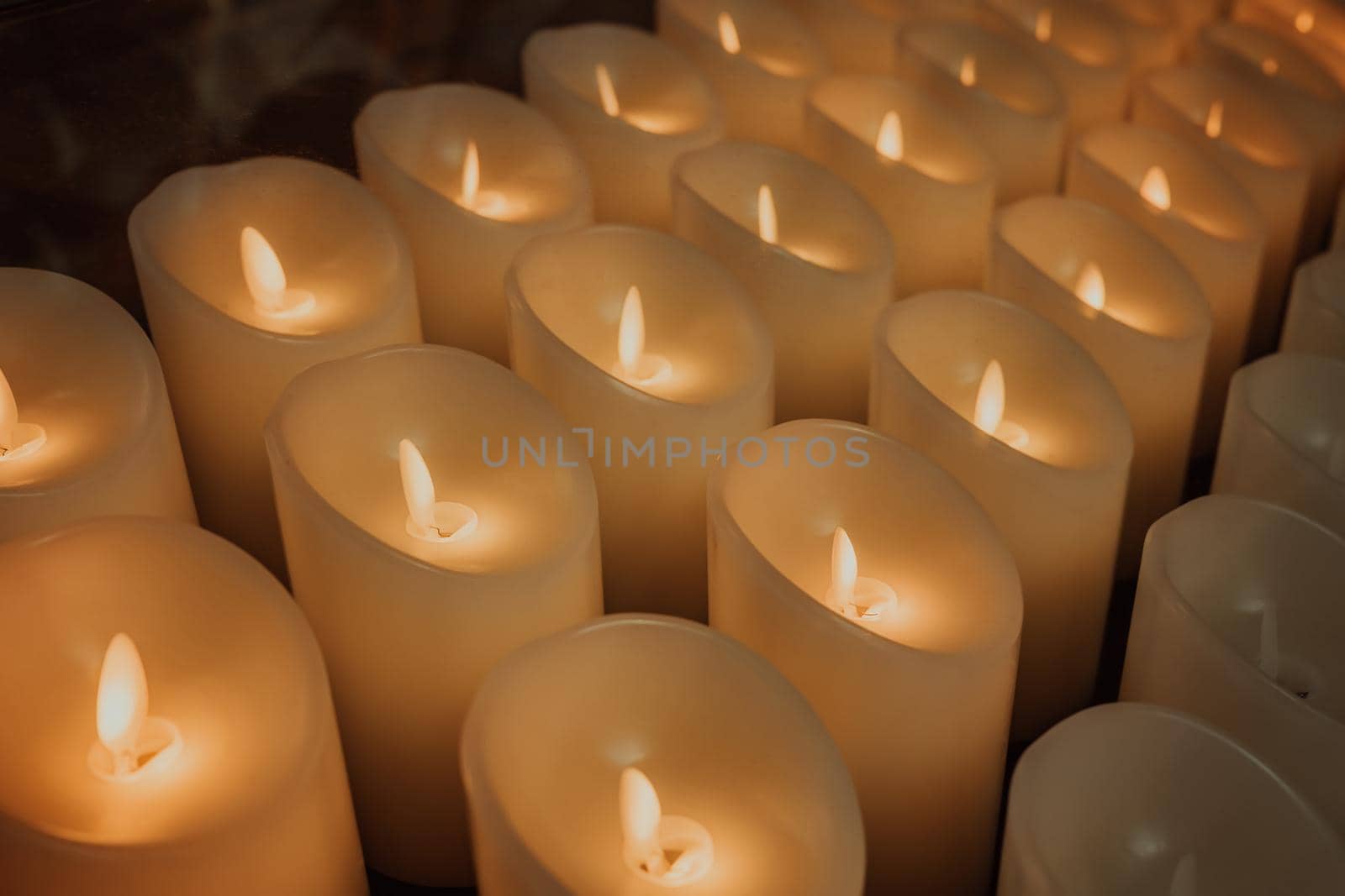 Candles burning brightly. Modern memorial candle on batteries in church. Abstract background. High quality photo