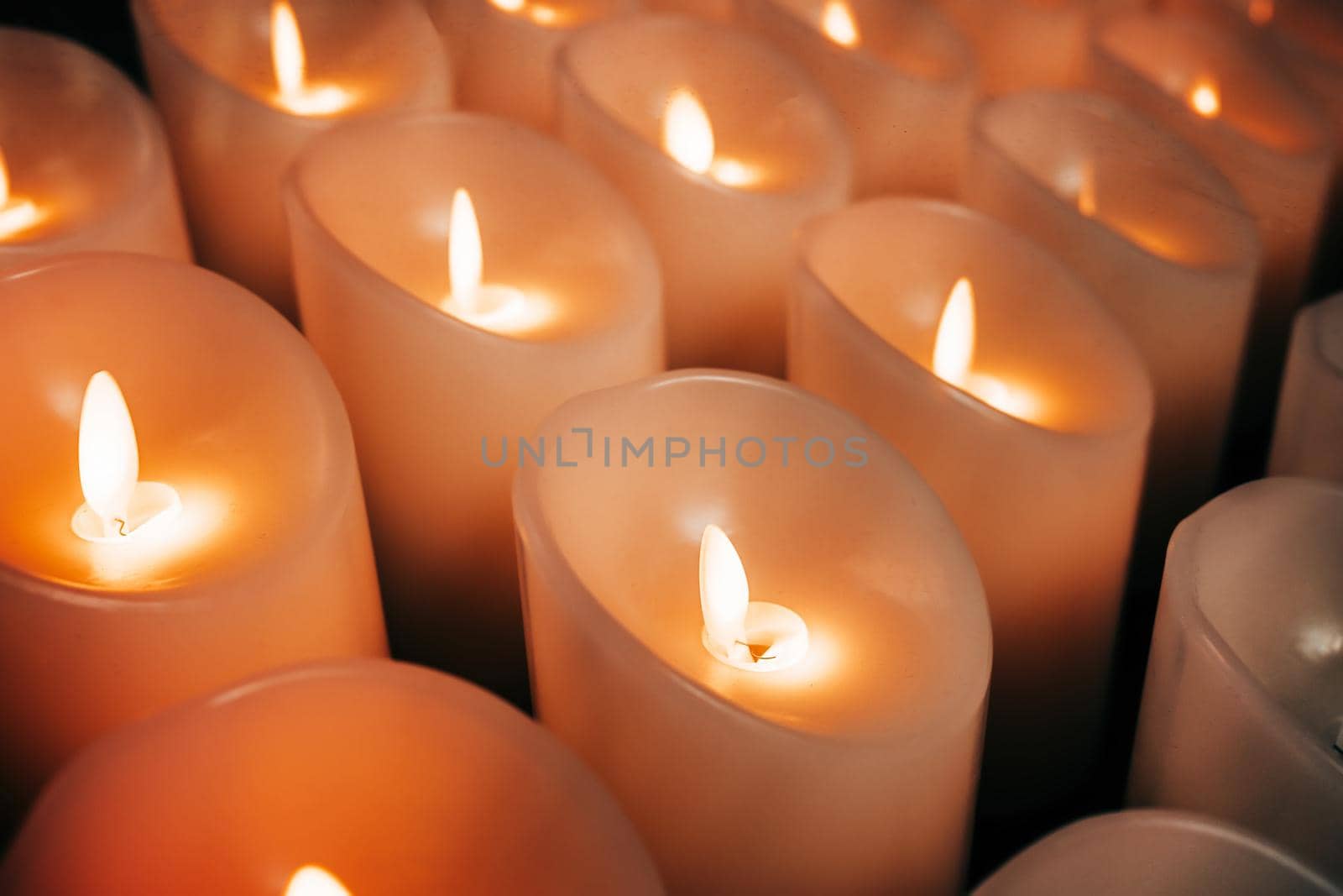 Candles burning brightly. Modern memorial candle on batteries in church. Abstract background. High quality photo