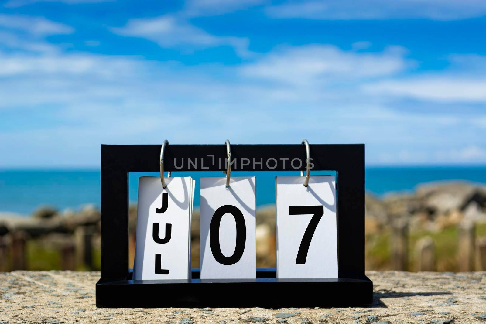 Jul 07 calendar date text on wooden frame with blurred background of ocean. Calendar date concept.