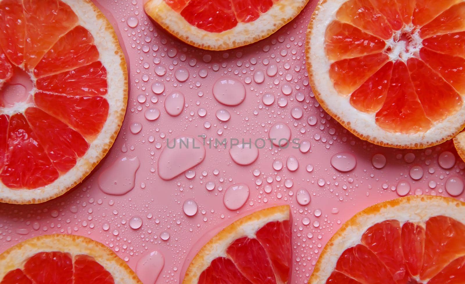 Background with grapefruit and water drops. Selective focus. by yanadjana