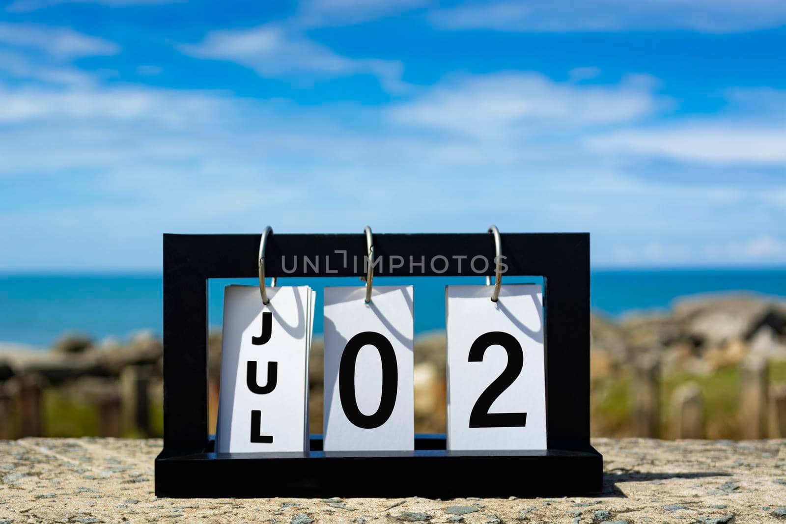 Jul 02 calendar date text on wooden frame with blurred background of ocean. Calendar date concept.