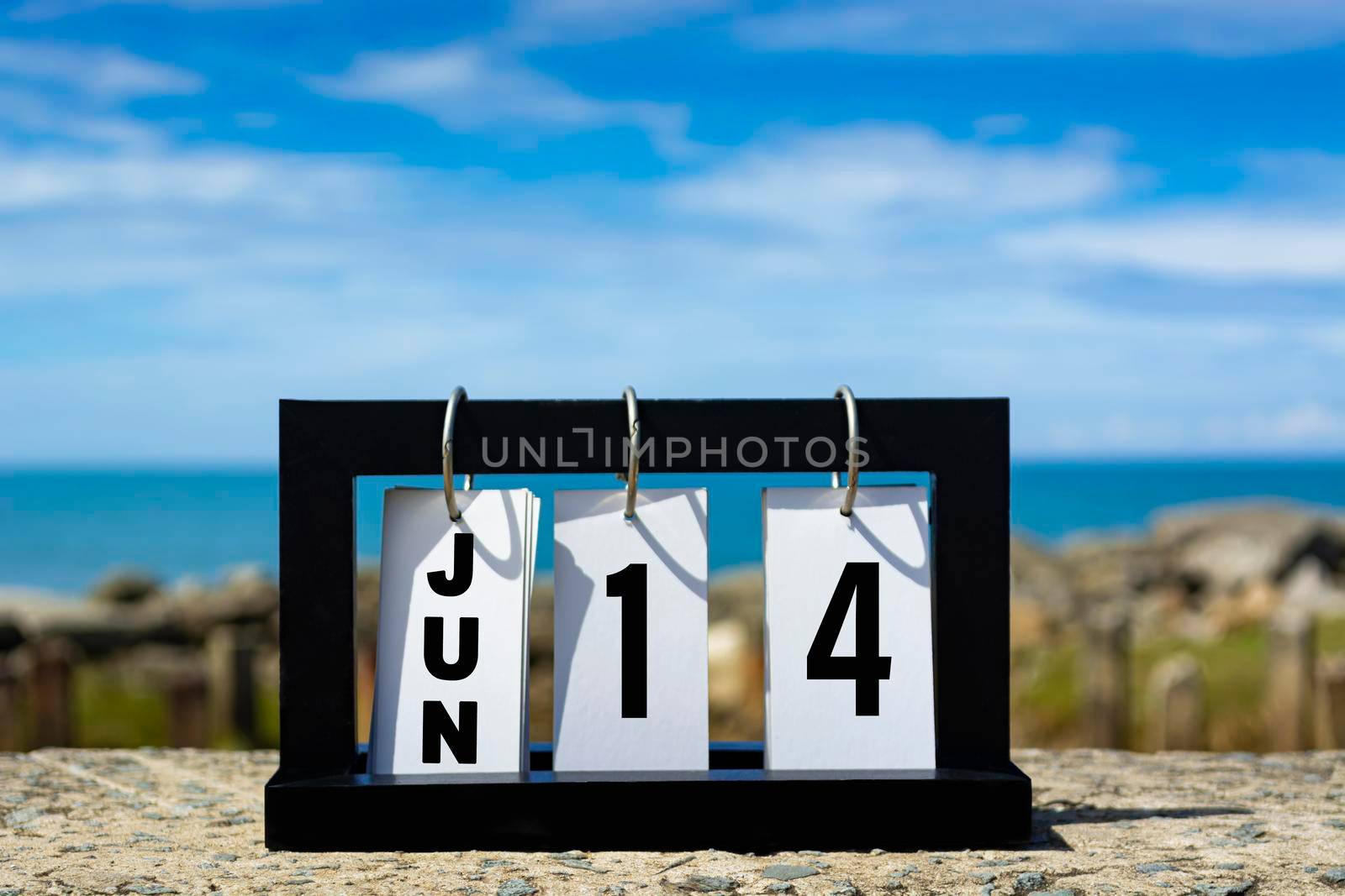 Jun 14 calendar date text on wooden frame with blurred background of ocean. Calendar date concept.