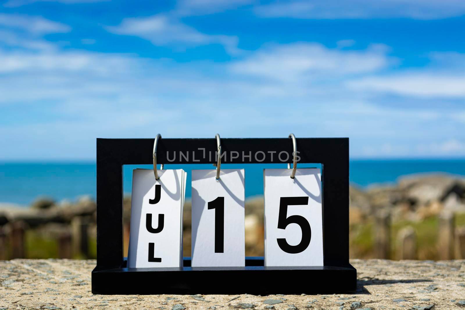 Jul 15 calendar date text on wooden frame with blurred background of ocean. Calendar date concept.