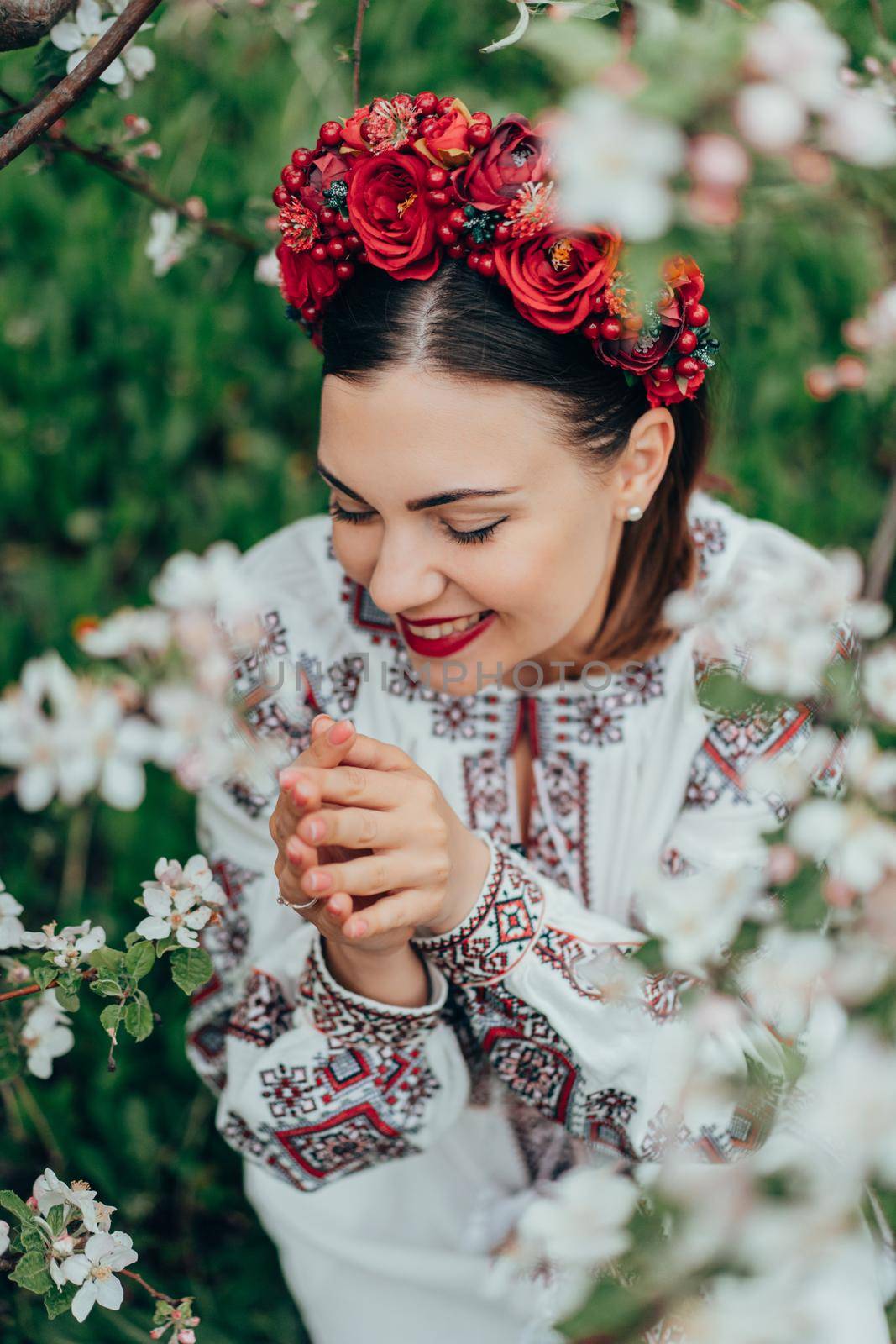 Attractive ukrainian woman in traditional embroidery vyshyvanka dress and red flowers wreath. Ukraine, freedom, culture, national costume, victory in war. High quality photo