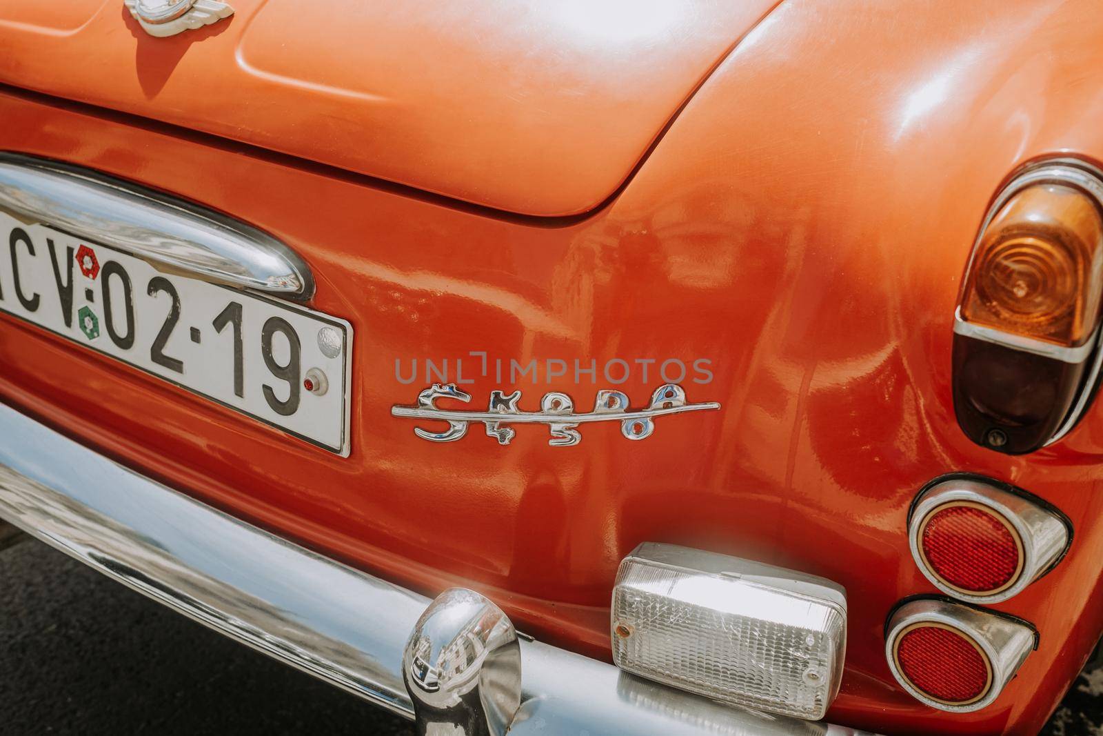 Prague, CZECH REPUBLIC - July 2022. Detail of retro Skoda automobile brand, logo close-up view. 450 orange roadster. Symbol of Czech vintage car maker and producer . High quality photo