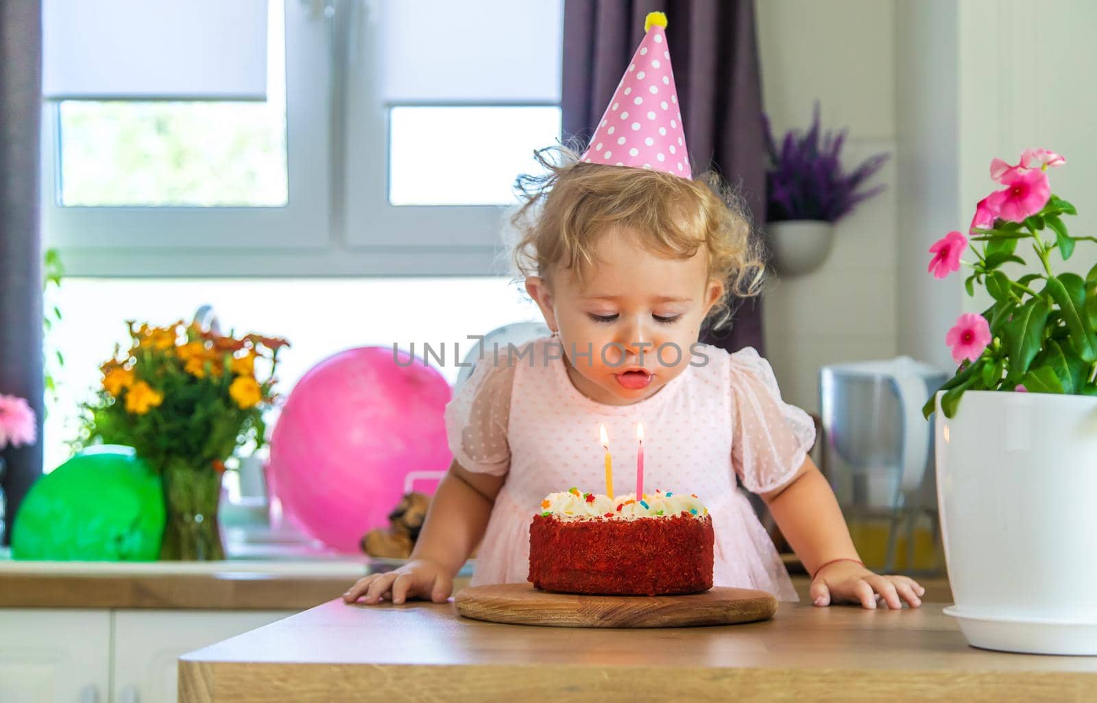 Child is two years old with a cake and candles. Selective focus. Kid.