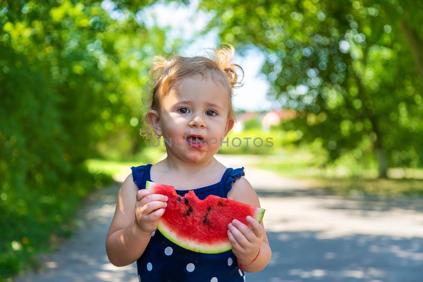 A child eats watermelon in the park. Selective focus. Kid.