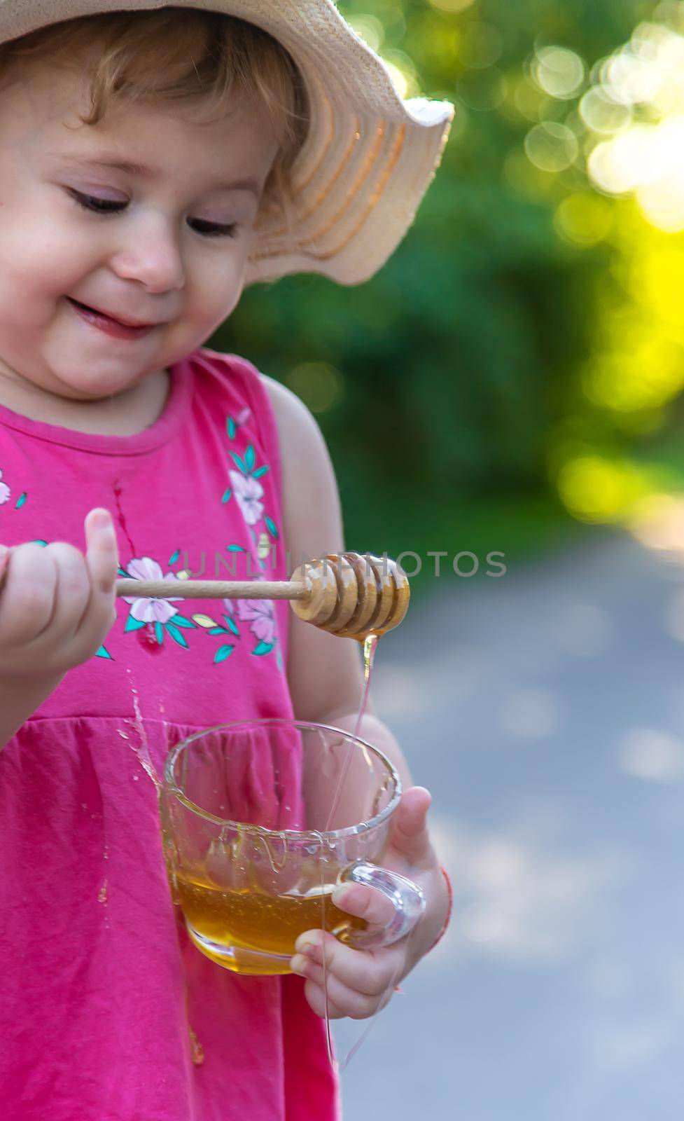 A child eats honey in the park. Selective focus. Kid.